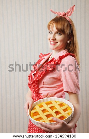 Retro housewife holding hot italian pie.