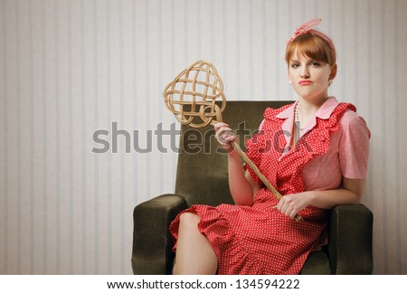 Ironic portrait of a housewife retro sitting in an armchair