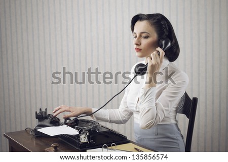 Perfect secretary talking on phone at desk