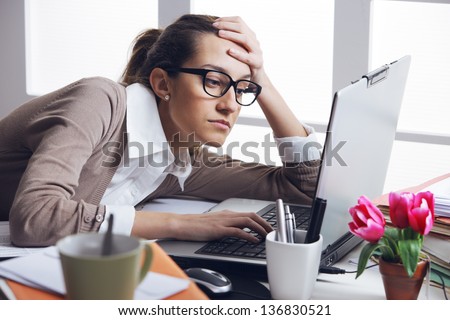 Young and beautiful businesswoman tired from work in the office.Woman holding her head