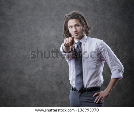 Young business man in suite, pointing at camera