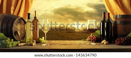 Wine Bottles, Barrels And Vineyard In Sunset