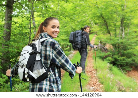 Young couple enjoying nordic walking in a forest