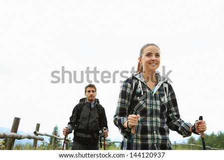 Young couple enjoying a nordic walk, woman is smiling