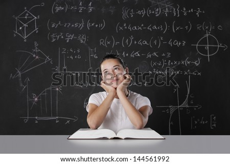 Student sitting in front of a blackboard filled with mathematical formulas. thinks about his future