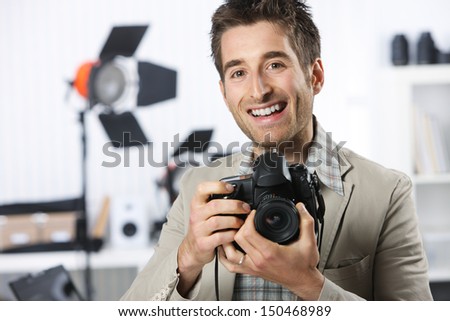 Portrait of young male photographer with professional digital camera