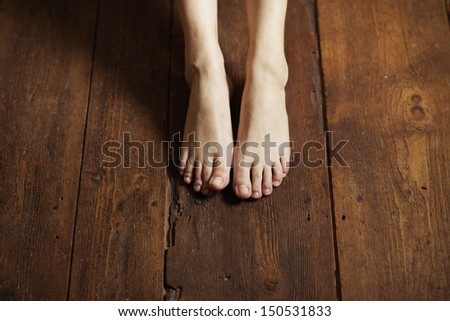 Cropped image of female bare feet on a wooden floor