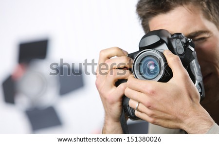 Young man taking photo with professional digital camera