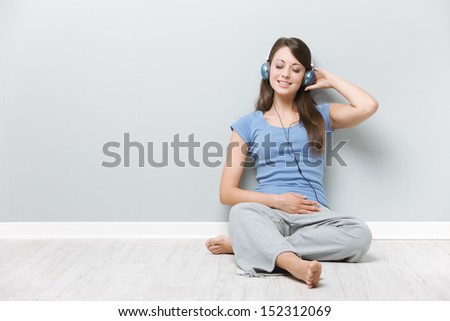 Beautiful young woman enjoying music through her headphones
