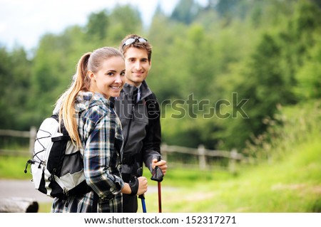 Young cheerful couple enjoying a nordic walk