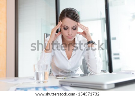 Overworking business woman suffering from headache