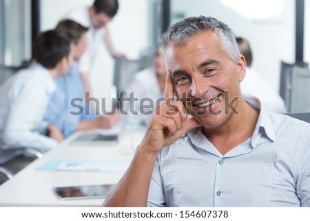 Portrait Of A Handsome Businessman, Blurred Colleagues In The Background
