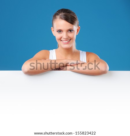 Attractive young woman leaning on a blank placard