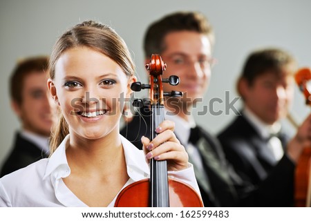 Portrait of a beautiful female violinist, musicians on background