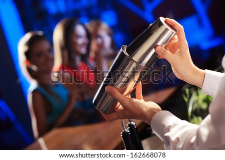 Bartender Shaking A Cocktail, Young Women On The Background