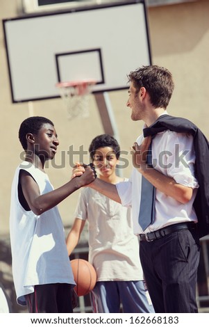 Multi-Ethnic Basketball players shaking hands after match