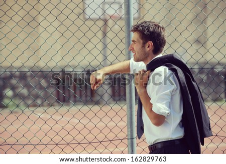 Young Business man looking away, basketball court on background