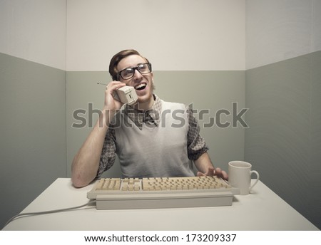 Vintage nerd guy talking on the phone and typing.