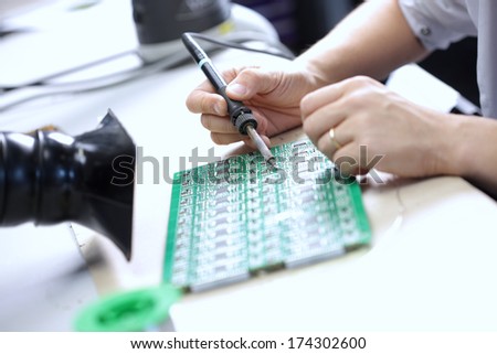 Technician assembling electronic components at his worktable.