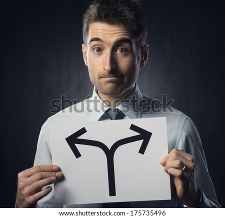 Man holding a sign with directions and pensive expression.