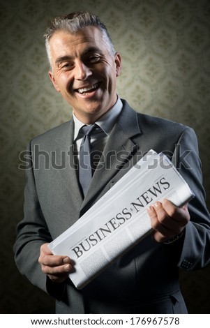 Handsome businessman holding newspaper against vintage wallpaper background.