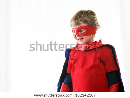 Smiling super hero kid with red mask and cape close up.