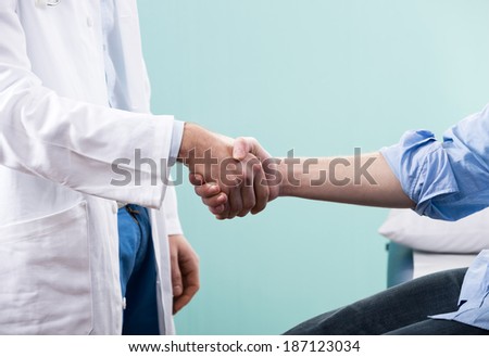 Doctor and patient handshake close-up at the clinic.
