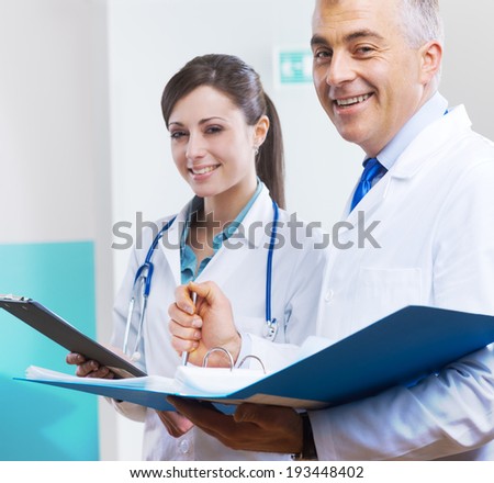 Young assistant and doctor checking medical records and documents.