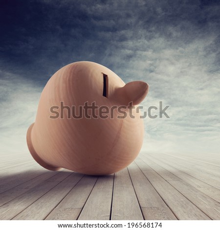 Clay coin bank on wooden plank floor with cloudy sky on background.