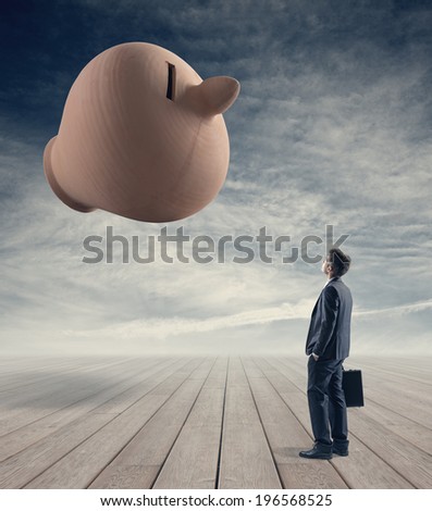 Businessman with briefcase contemplating a huge clay coin bank with sky on background.