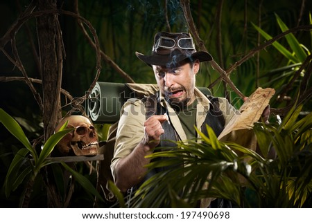Explorer with map smoking in the jungle and finding a human skull.