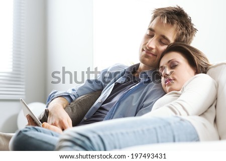 Young loving couple sleeping on sofa in the living room.
