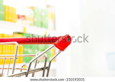 Shopping cart detail close-up with store shelf on background.