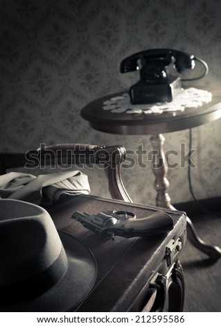 Detective equipment with briefcase, hat and gun, vintage interior on background.
