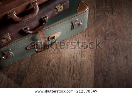 Vintage luggage close-up on dark hardwood floor, travelling concept.