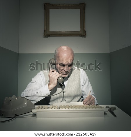 Office worker on the phone in his small office.