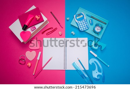 Opposites attract concept with male light blue desk and girly pink desk, stationery and heart shaped stick notes.