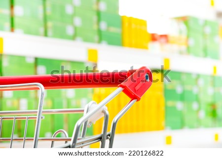 Shopping cart detail close-up with store shelf on background.