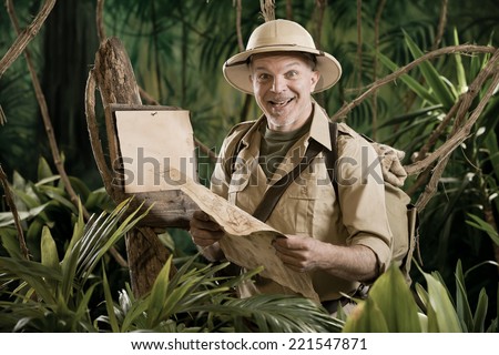 Cheerful vintage explorer in the jungle with map and blank sign.
