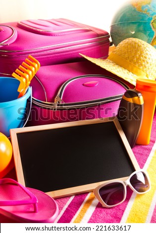 Empty blackboard with summer holidays background, including sunglasses, sun cream and bag.