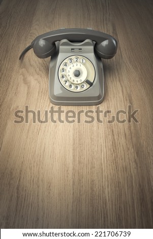 Vintage gray telephone on hardwood surface desk or floor.