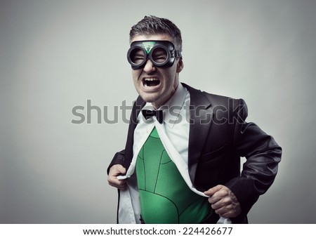 Elegant superhero taking off shirt and jacket and showing green costume underneath.