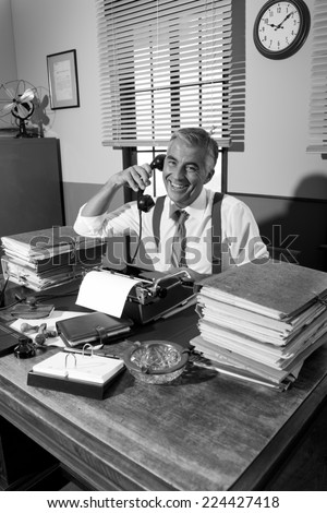 Vintage professional journalist on the phone working at office desk.