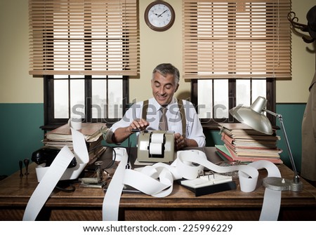 Busy vintage accountant with adding machine surrounded by cash register tape.