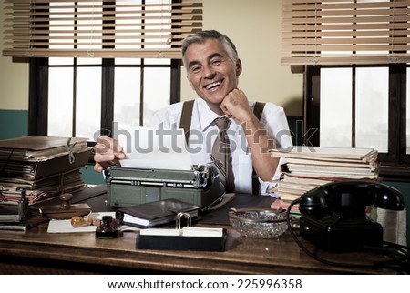 Smiling reporter working at office desk with vintage typewriter, 1950s style.