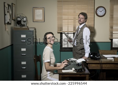 Director with paperwork and young secretary typing on typewriter in an elegant vintage office.