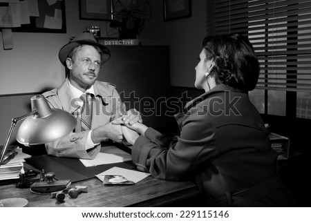 Handsome supportive detective at office desk holding a young woman\'s hands and comforting her, film noir.