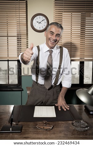 Cheerful vintage businessman thumbs up and smiling at camera.