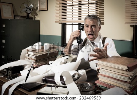 Angry vintage businessman shouting out loud at phone surrounded by adding machine tape.