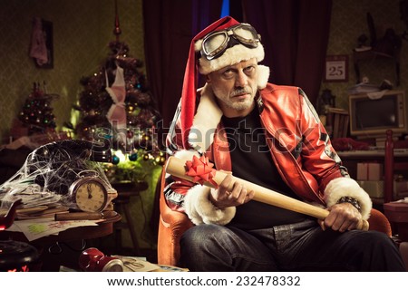 Frowning Bad Santa with baseball bat gift looking at camera